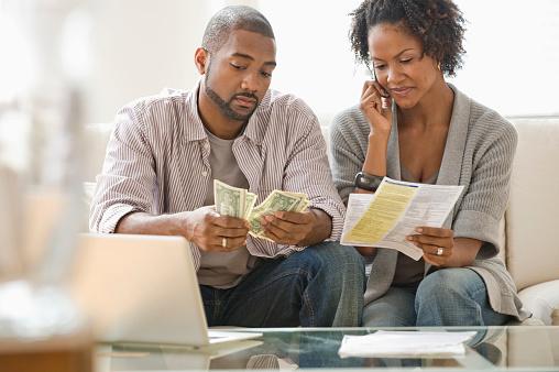 Couple counting money and looking at bills